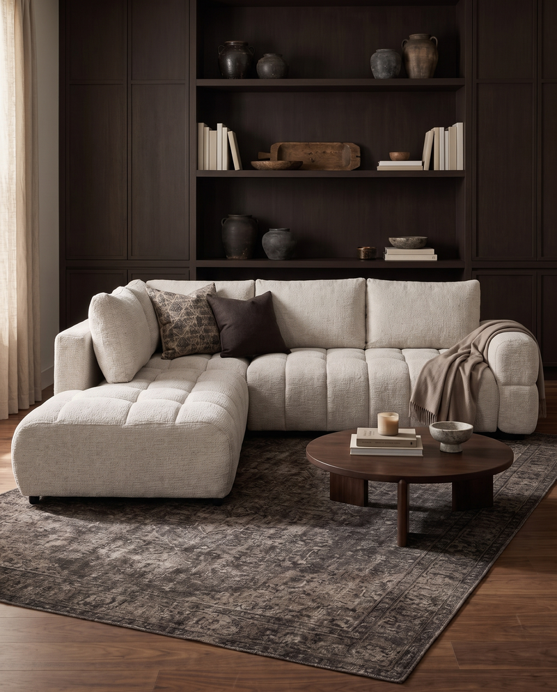 Aykah chenille Harmony Sectional in Ivory Melange, styled with a round coffee table and built-in shelving