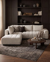 Aykah chenille Harmony Sectional in Ivory Melange, styled with a round coffee table and built-in shelving
