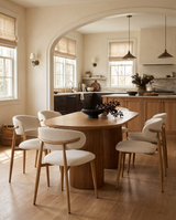 Bouclé Mabel Dining Chair with Oak-finish metal legs, six chairs around an oval fluted table in a sunlit kitchen